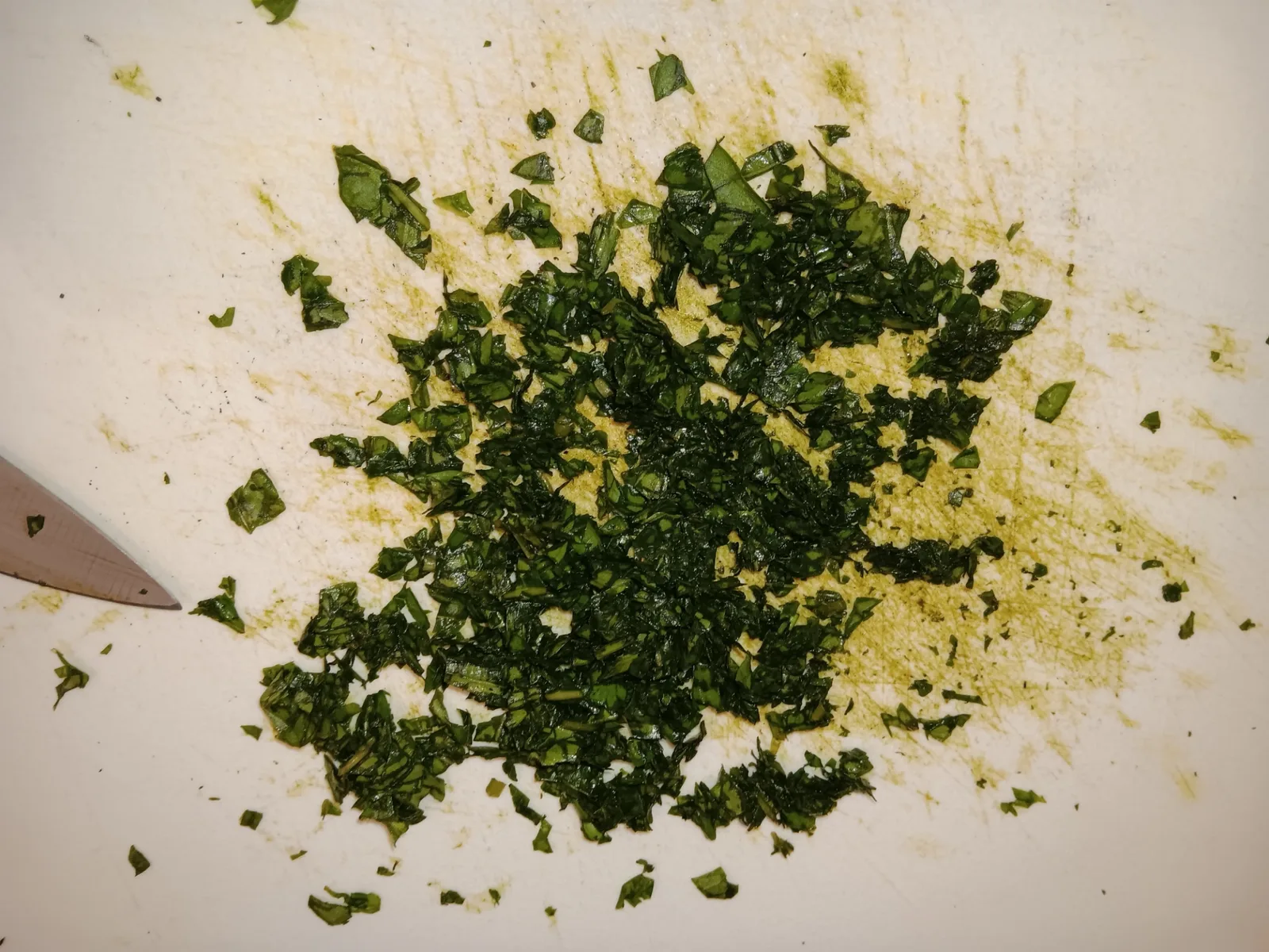 Fresh basil chopped into small pieces on a cutting board