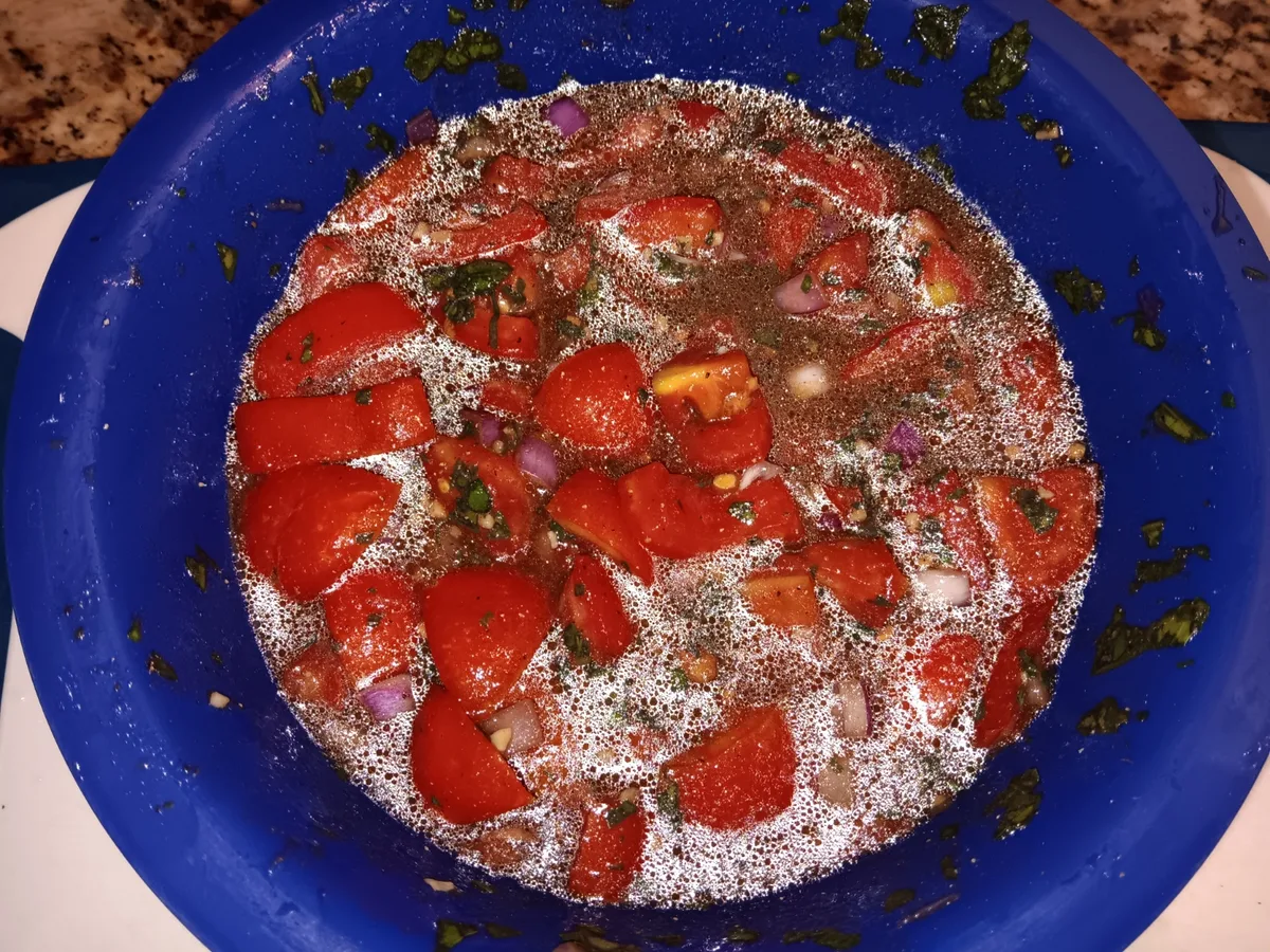 Tomatoes, basil, garlic, and chopped red onion mixed with olive oil and balsamic vinegar